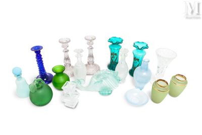 de nombreux vases en verre de différentes couleurs posés sur une surface blanche
