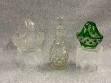 trois objets en verre posés sur une surface blanche