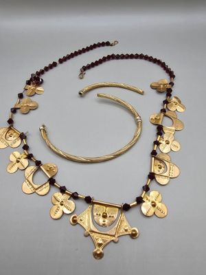 a close up of a necklace and bracelet on a table