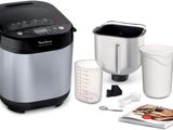 an image of a silver and black electric rice cooker next to a cup of coffee