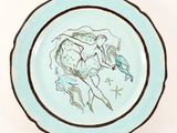 a blue plate with a drawing of a woman on a horse