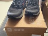 pair of black running shoes sitting on top of a box in a store