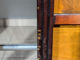 a close up of a door handle on a wooden cabinet