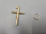 a gold cross and a gold ring on a white surface