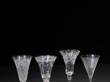 four wine glasses sitting on top of a table next to each other