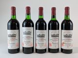 quatre bouteilles de vin sont alignées sur une surface blanche
