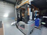 a forklift truck parked in a garage with other equipment