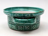 a green bowl sitting on top of a white table
