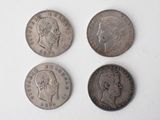 quatre types différents de pièces d'argent sur une surface blanche