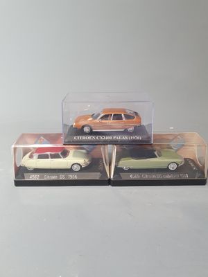 two toy cars are in a clear box on a white surface