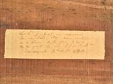 a piece of paper with writing on it on a wooden surface