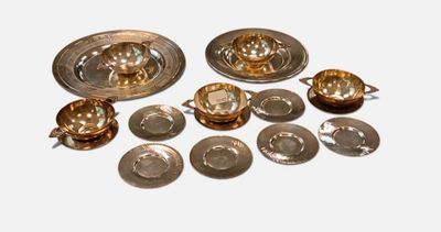 a lot of silver plates and bowls on the table