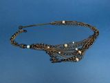 an image of a necklace with pearls and chains on a blue background