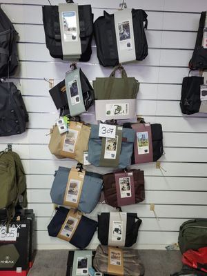 many pieces of luggage hanging on a wall in a store