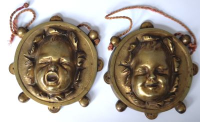 pair of antique brass wall plaques of a laughing child