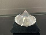 un objet en verre transparent posé sur une surface noire