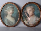 two framed portraits of a woman and a man in a blue dress