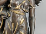 bronze statue of a woman holding a child on her back