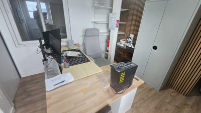 a desk with a computer on it in a small room