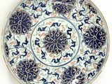 blue and white plate with floral designs on it on a white surface