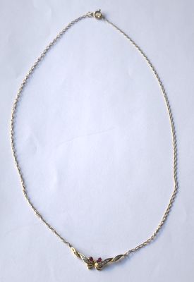 un gros plan d'un collier sur une surface blanche avec un fond blanc
