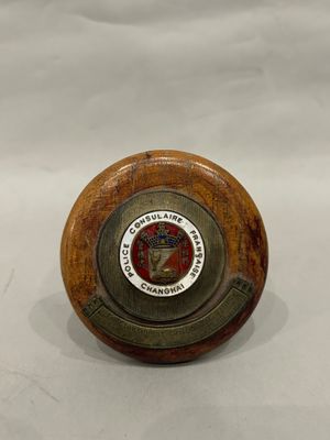 a small wooden object with a seal on it