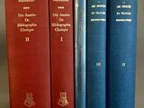 trois livres sont alignés les uns à côté des autres sur une surface grise