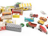 un tas de petites voitures et de camions miniatures posés sur une surface blanche