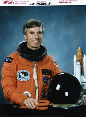 une image représentant un homme vêtu d'une combinaison spatiale orange et tenant un casque