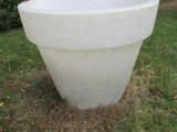 une grande jardinière blanche posée au milieu de la pelouse