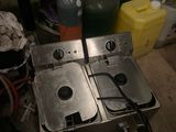 two deep fryers that are sitting on a table