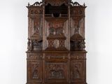 un vieux vaisselier en bois orné de sculptures raffinées sur le dessus