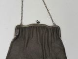 un vieux sac à main en maille argentée, muni d'une poignée et d'une bandoulière en chaîne