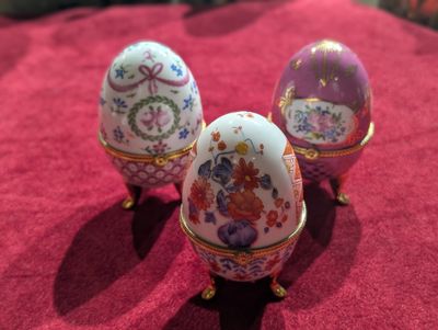 trois œufs décorés posés sur une nappe rouge