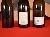 three bottles of wine sitting on a table next to each other