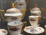 many cups and saucers on display in a glass case