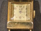 une montre en or posée sur une table noire