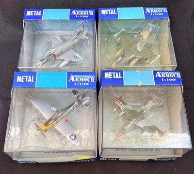 trois maquettes d'avions en métal dans leurs boîtes, posées sur une surface noire