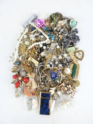 a pile of assorted jewelry on a white surface