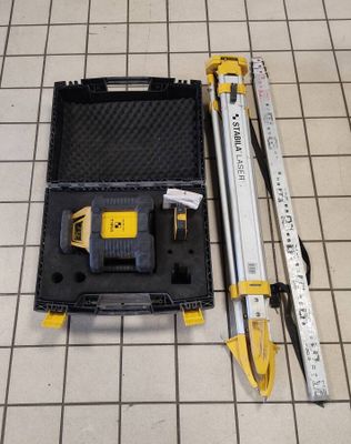 a tool set up on a tiled floor next to a ruler