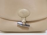 the back of a white purse with a metal clasp on it