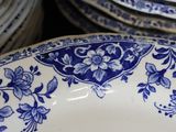 a lot of blue and white plates stacked on top of each other