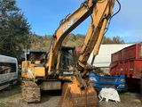 une pelleteuse jaune qui est à l'arrêt dans la terre