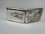 two silver plated cufflinks with a mountain scene engraved on them
