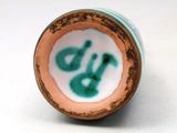 a close up of a vase with a green and white design on it
