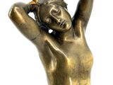 bronze statue of a woman with her hands behind her head
