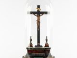 a statue of jesus on the cross under a glass dome