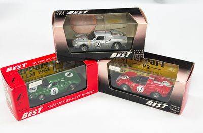 trois modèles différents de voitures dans des boîtes, posées sur une surface blanche