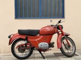a red motorcycle parked in front of a building