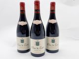 trois bouteilles de vin rouge posées sur une table blanche